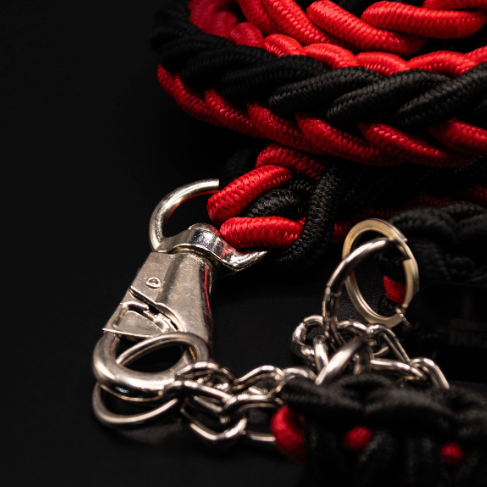 Nahaufnahme des rot-schwarzen Basic-Hundehalsbands von Strong Dogs U.S. mit geflochtener Struktur und Metallkette.